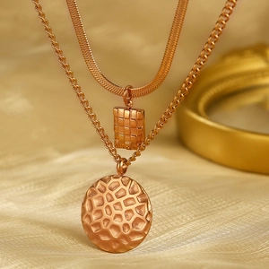 Detailed macro view of layered gold necklace featuring honeycomb square and hammered round pendants