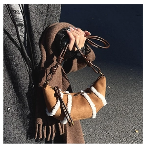Nahaufnahme braune Wildleder-Croissant-Tasche mit Pelzbesatz und geknotetem Riemen