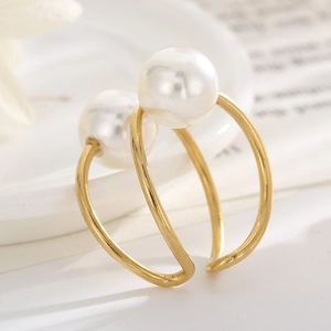 Close-up of double-layered gold open ring with dual white pearls on a soft background