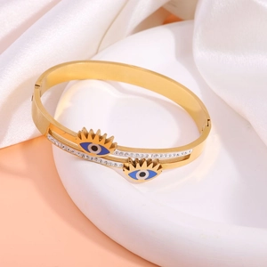 Detailed close-up of golden Evil Eye bangle with double layer design and crystal accents