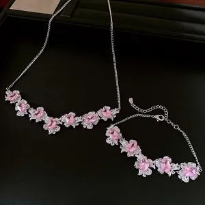 Elegant silver-tone jewelry set featuring pink zircon flower pendant necklace and bracelet