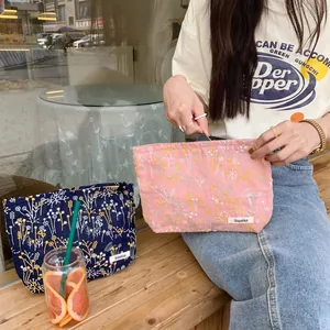Detailed embroidery of floral patterns on linen fabric makeup bags with zipper closure