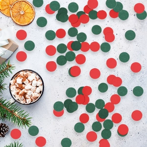 Close-up of red and green round Christmas confetti scattered on a festive background