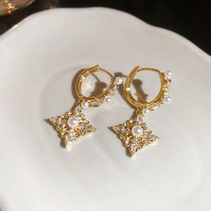 Macro shot of 18K gold plated hoop earring with pearl and diamond rhombus pendant