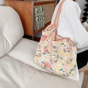 Close-up of floral drawstring tote bag showing the canvas texture and printed pattern