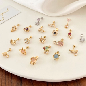 Flat lay of gold and silver stud earrings with zircon stars and moons on a tray