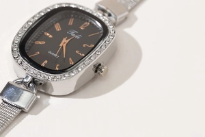 Close-up of elegant women's quartz watch with rhinestone bezel and silver mesh strap