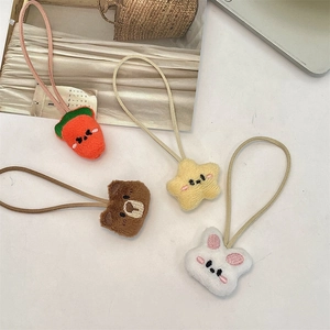 Close-up of plush hair ties featuring carrot, star, bear, and rabbit cartoon designs