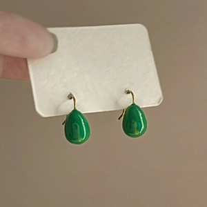Detail of French style green enamel teardrop earrings with elegant gold hooks