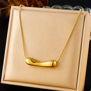 Polished gold irregular molten heart pendant on sleek snake chain over champagne satin