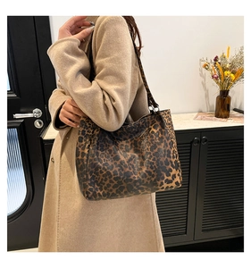 Detailansicht der Leopard-Print-Einkaufstasche an Model in beigem Wintermantel