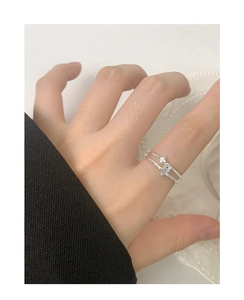 Close-up of double-layered silver star ring with zircon stones worn by a model
