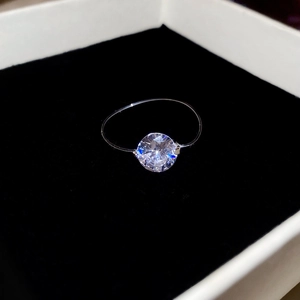Macro shot of a large round zircon stone set on a minimalist thin silver ring in a black box
