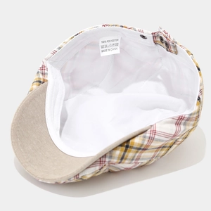 Detailed view of the white inner lining and washing label of a plaid flat cap