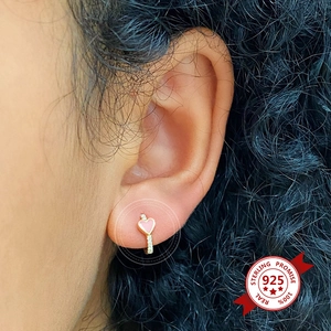 Close-up of pink heart hoop earring with S925 silver needle on model ear with zircon