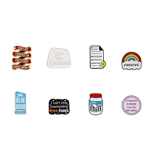 Detail view of eight colorful enamel pins with creative slogans and rainbow designs