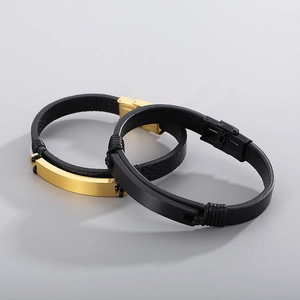 Nahaufnahme von Herren-Lederarmbändern mit gebürsteten schwarzen und goldenen Metallplatten
