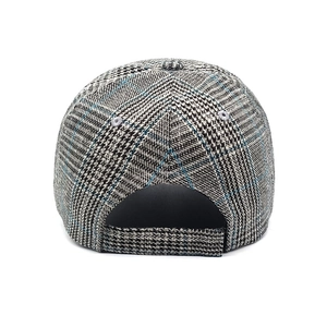 Detail of retro houndstooth baseball cap featuring an adjustable fabric back strap