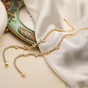 Detailed view of 18K gold plated tennis bracelets with LOVE and MAMA zircon lettering