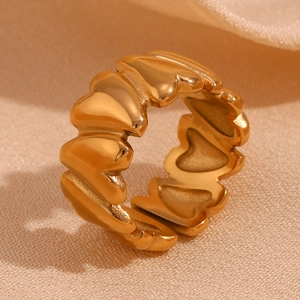Macro shot of gold-plated 18K stainless steel ring featuring linked heart-shaped patterns