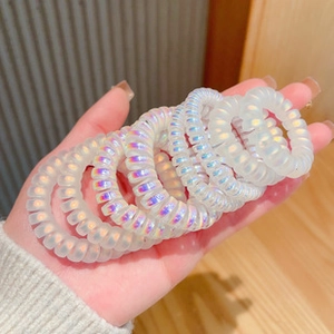 Close-up of shimmering pearlescent spiral hair ties in a handheld macro view