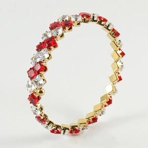 Detailed macro view of 18k gold-plated bangle with red and white square zircon inlays