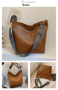 Detail view of brown bucket bag with lychee texture and blue floral jacquard strap
