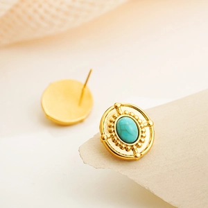 Macro detail of vintage 18K gold earrings with oval turquoise inlay and dotted texture