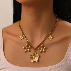 Close-up of gold flower necklace with thick chain showing textured petals on a model
