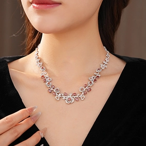Detail of vintage silver necklace with red oval gemstone and floral crystal pattern