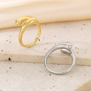 Dettaglio di anelli aperti a goccia minimalisti in acciaio lucido oro e argento