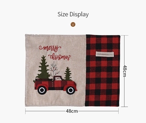 Detail of linen Christmas placemat with red truck embroidery and buffalo plaid pattern
