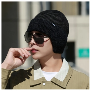 Gros plan d'un bonnet en tricot noir avec doublure polaire épaisse et étiquette FBHS