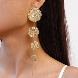 Detail of gold drop earrings featuring four graduated spiral textured metal discs