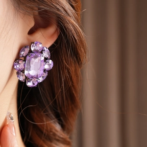 Gros plan de boucles d'oreilles vintage avec pierre violette et cristaux brillants