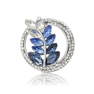 Sparkling vintage silver brooch with blue and clear crystal leaves in a round design