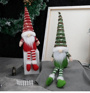 Detail of red and green knitted Christmas gnomes with long legs and white beards