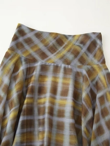 Close-up of elastic waistband and plaid pattern detail on the midi skirt for women