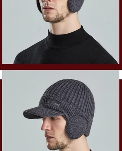 Detail showing the dark grey knit texture, peak brim, and ear flaps of the winter sport hat