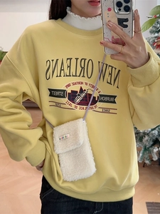 Cute white plush crossbody phone bag paired with a yellow graphic New Orleans sweatshirt
