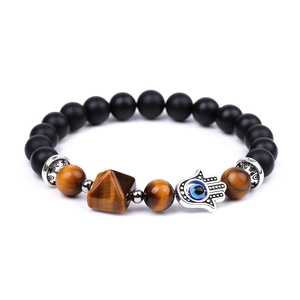 Detail of beaded bracelet with black matte beads, tiger eye stones, and Hamsa hand charm