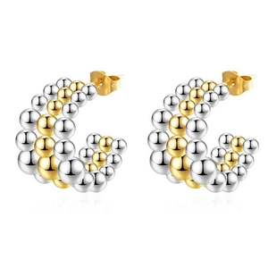 Detail shot of C-shaped earrings with two-tone silver and gold metal bead design