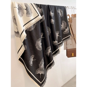 Thick ginkgo leaf pattern pashmina scarf in black and beige with fringe on a hanger