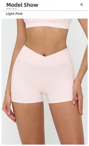 Detail of high-waist yoga shorts in pale pink with V-cross waistband and side pockets