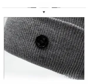 Close-up of grey ribbed knit beanie with a black circular logo detail on the front