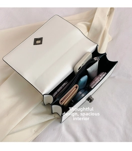 Detailed interior of white chain bag showing spacious compartments with phone and wallet