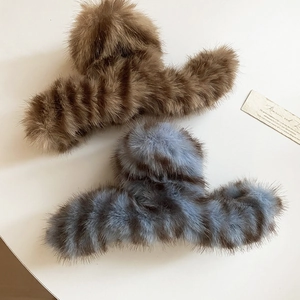Detailed view of large plush hair claws in brown and blue grey faux fur texture