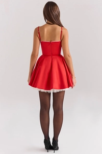 Detail of red satin backless mini dress with lace hem and smooth glossy texture