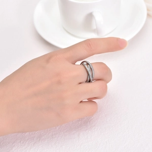 Close-up of frosted interlocking triple rings on finger with a minimalist white aesthetic