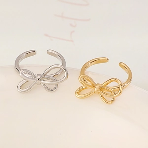 Macro shot of gold and silver bow-shaped open rings with a polished mirror finish